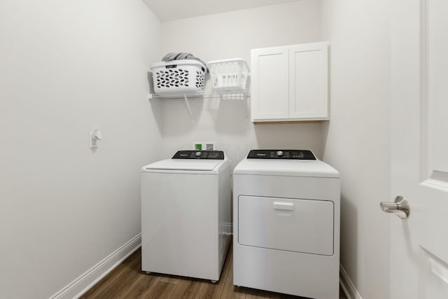 laundry room featuring dark wood-type flooring, baseboards, washing machine and clothes dryer, and cabinet space