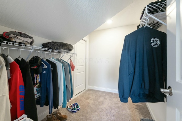 spacious closet featuring vaulted ceiling and carpet floors