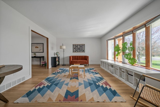 living area with visible vents and wood finished floors