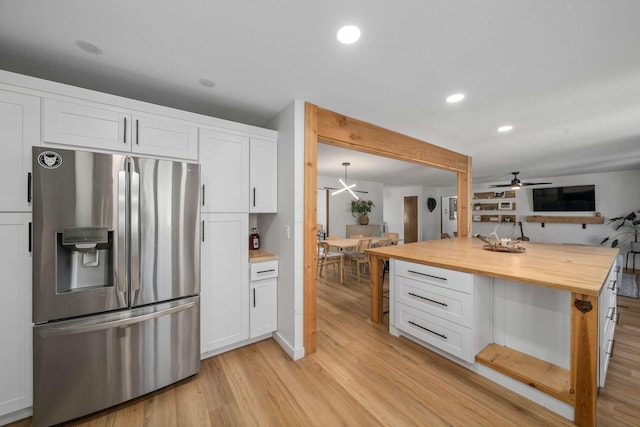 kitchen featuring light wood-type flooring, a ceiling fan, white cabinetry, stainless steel refrigerator with ice dispenser, and wood counters
