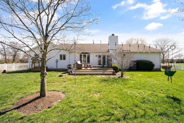 back of property featuring a yard, a wooden deck, and fence