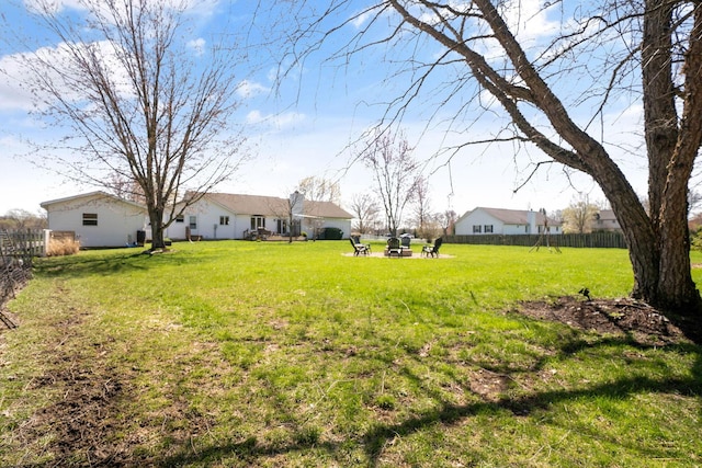 view of yard with a fire pit and fence