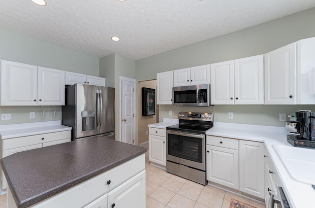 4497 Battles St, New Albany, OH 43054 - kitchen with stainless steel appliances, light tile patterned floors, white cabinets, a sink, and recessed lighting