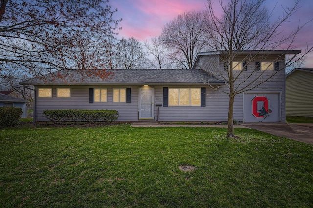 view of front of house featuring driveway, a garage, and a lawn
