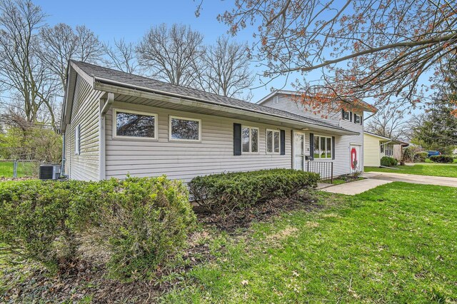 traditional-style house featuring a front yard and central AC unit