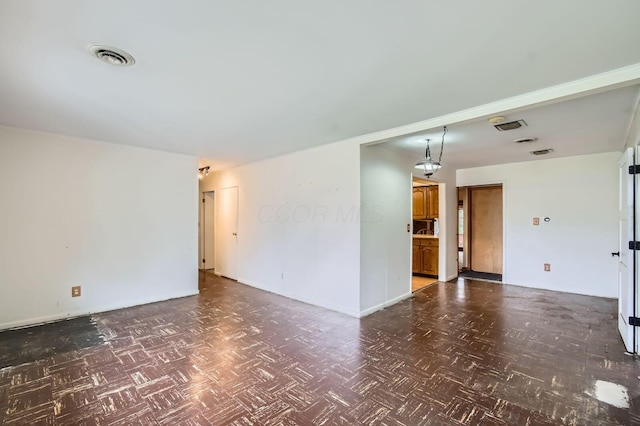 empty room featuring visible vents and baseboards