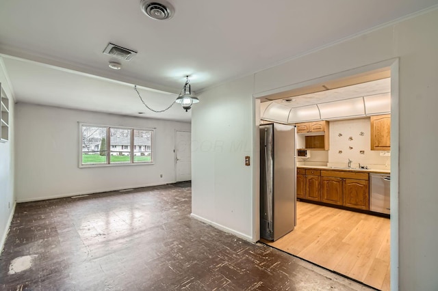 interior space with a sink, visible vents, light countertops, and stainless steel appliances