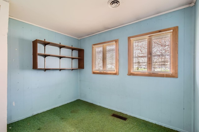 carpeted empty room featuring baseboards and visible vents