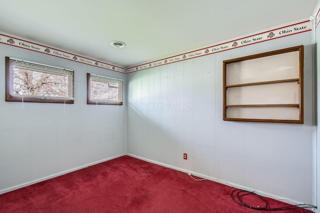empty room featuring visible vents, baseboards, and carpet