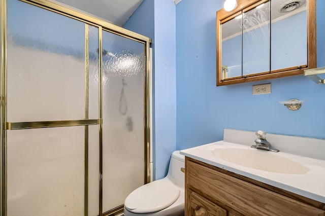 bathroom featuring visible vents, toilet, a stall shower, and vanity