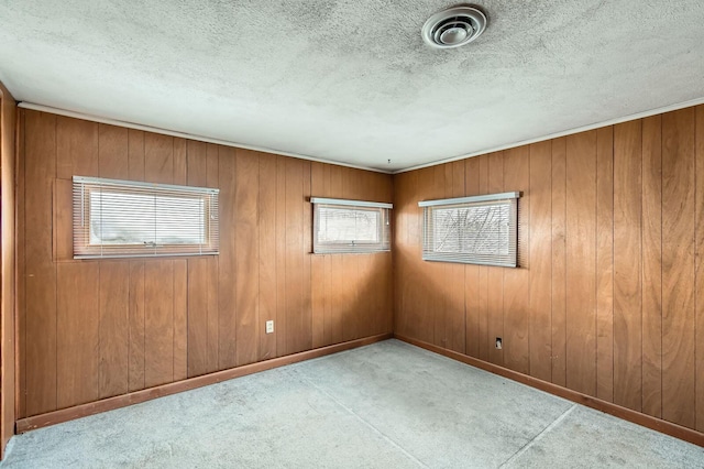 unfurnished room featuring carpet, visible vents, a textured ceiling, and baseboards