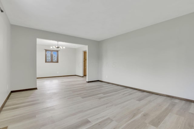 8015 Alspach Rd NW, Lancaster, OH 43130 - spare room featuring a chandelier, light wood-type flooring, and baseboards