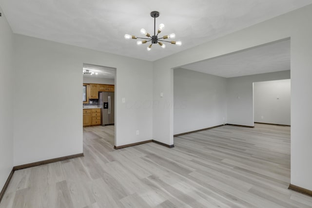 8015 Alspach Rd NW, Lancaster, OH 43130 - unfurnished room with light wood-style flooring, baseboards, and an inviting chandelier