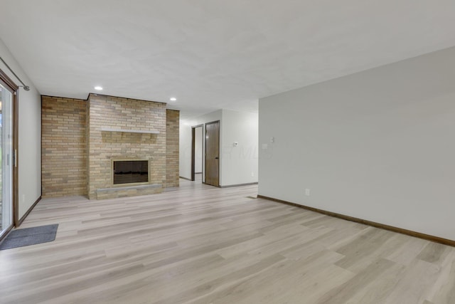 8015 Alspach Rd NW, Lancaster, OH 43130 - unfurnished living room featuring a brick fireplace, recessed lighting, light wood-style floors, and baseboards