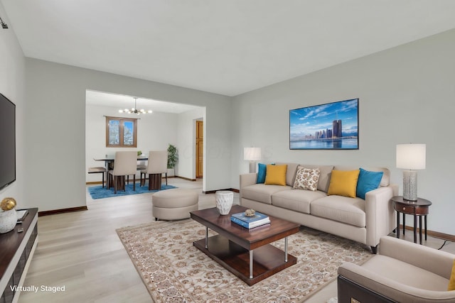 8015 Alspach Rd NW, Lancaster, OH 43130 - living room with baseboards, an inviting chandelier, and light wood-style floors