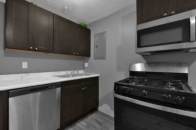 820 Poplar St Unit 820/822, Nelsonville, OH 45764 - kitchen with a textured ceiling, a sink, dark brown cabinetry, appliances with stainless steel finishes, and electric panel