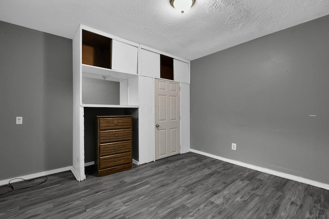 820 Poplar St Unit 820/822, Nelsonville, OH 45764 - unfurnished bedroom with a textured ceiling, baseboards, and dark wood-style flooring
