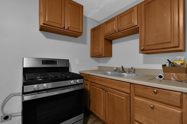 820 Poplar St Unit 820/822, Nelsonville, OH 45764 - kitchen with light countertops, a sink, stainless steel gas range, a textured ceiling, and brown cabinetry
