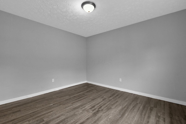 820 Poplar St Unit 820/822, Nelsonville, OH 45764 - unfurnished room featuring dark wood-type flooring, a textured ceiling, and baseboards