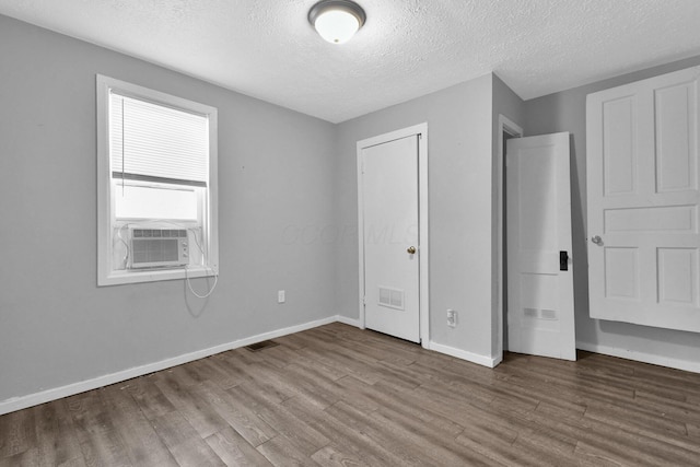 820 Poplar St Unit 820/822, Nelsonville, OH 45764 - unfurnished bedroom with cooling unit, baseboards, a textured ceiling, visible vents, and wood finished floors