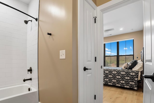 full bathroom featuring ensuite bath, shower / washtub combination, and wood finished floors