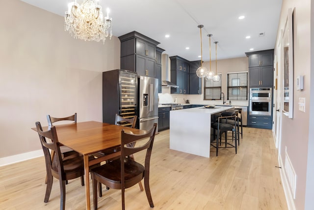 dining room with a chandelier, light wood-type flooring, visible vents, and recessed lighting