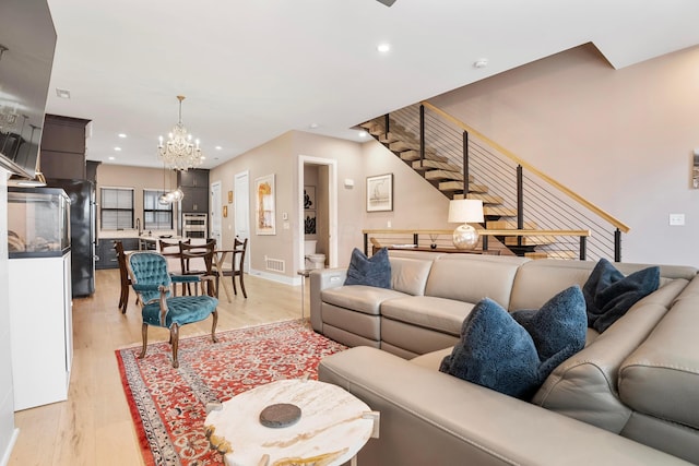 living area featuring a notable chandelier, recessed lighting, stairs, and light wood-type flooring
