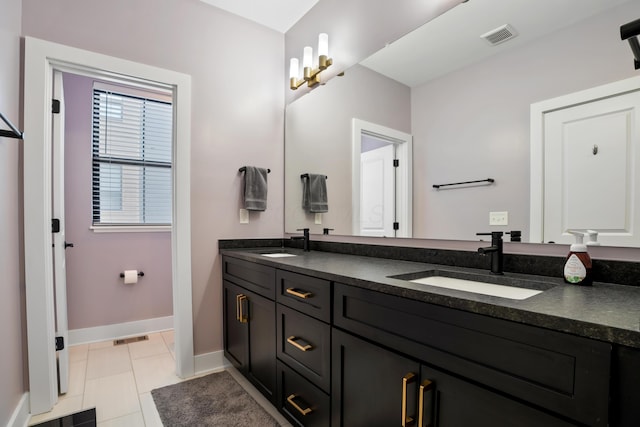 bathroom with baseboards, a sink, visible vents, and double vanity