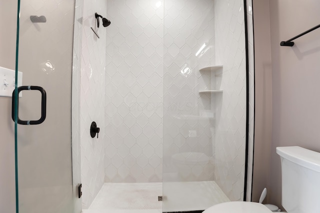 bathroom with a shower stall and toilet