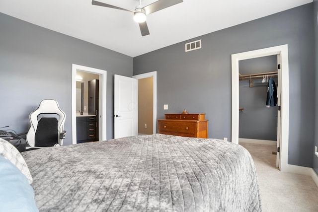 bedroom with visible vents, a spacious closet, a ceiling fan, a closet, and carpet floors