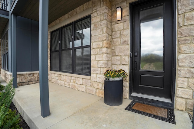 property entrance with stone siding and covered porch