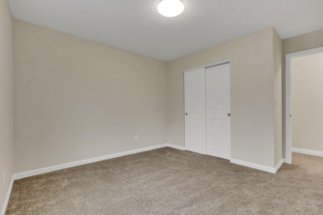 574 Koebel Ave, Columbus, OH 43207 - unfurnished bedroom featuring a closet, carpet floors, and baseboards