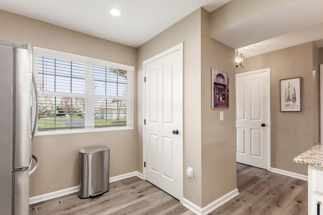 interior space featuring a wealth of natural light, light wood finished floors, and baseboards
