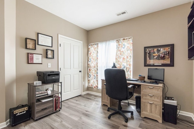 office area featuring visible vents, light wood finished floors, and baseboards