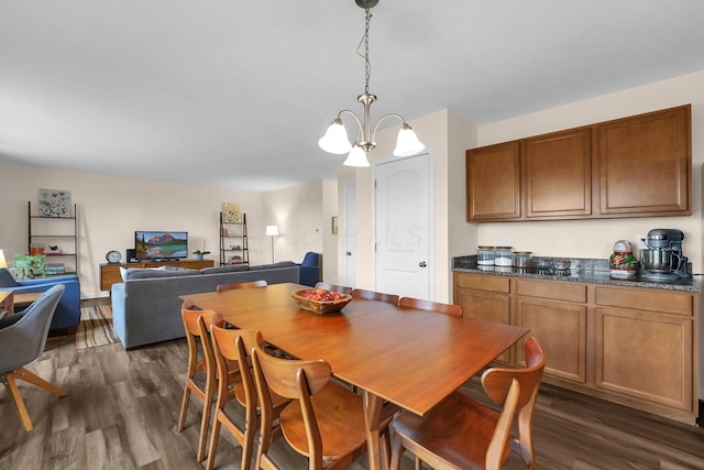 dining area with dark wood-style flooring and an inviting chandelier