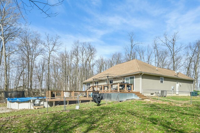 21100 Fleckinger Rd, West Mansfield, OH 43358 - rear view of house featuring a wooden deck, cooling unit, a lawn, fence, and a trampoline
