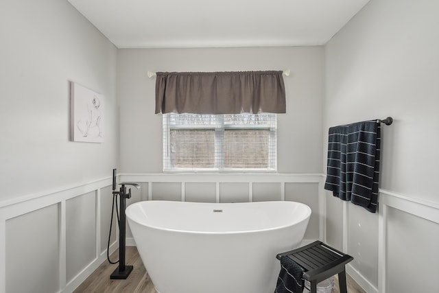 21100 Fleckinger Rd, West Mansfield, OH 43358 - full bathroom featuring a decorative wall, wood finished floors, a soaking tub, and wainscoting