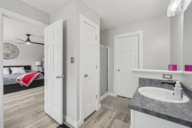 21100 Fleckinger Rd, West Mansfield, OH 43358 - bathroom featuring ceiling fan, vanity, wood finished floors, a stall shower, and baseboards