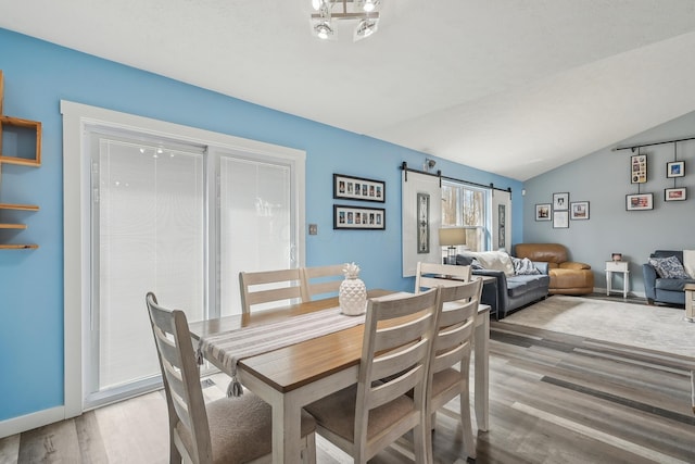 21100 Fleckinger Rd, West Mansfield, OH 43358 - dining space with light wood-style floors, baseboards, lofted ceiling, and a barn door