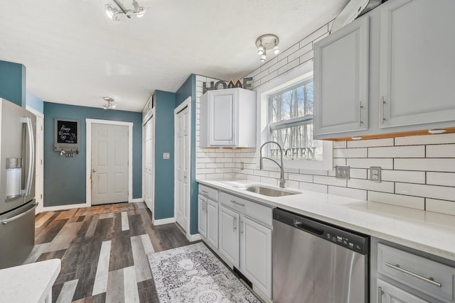 21100 Fleckinger Rd, West Mansfield, OH 43358 - kitchen featuring appliances with stainless steel finishes, baseboards, dark wood-style floors, decorative backsplash, and a sink