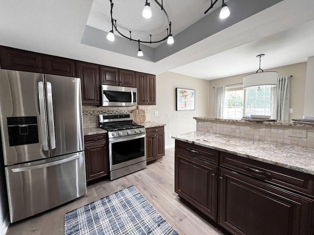 kitchen with decorative backsplash, dark brown cabinets, and stainless steel appliances