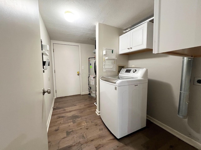 washroom with cabinet space, gas water heater, a textured ceiling, washer / clothes dryer, and wood finished floors