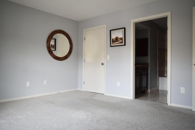 carpeted spare room featuring baseboards