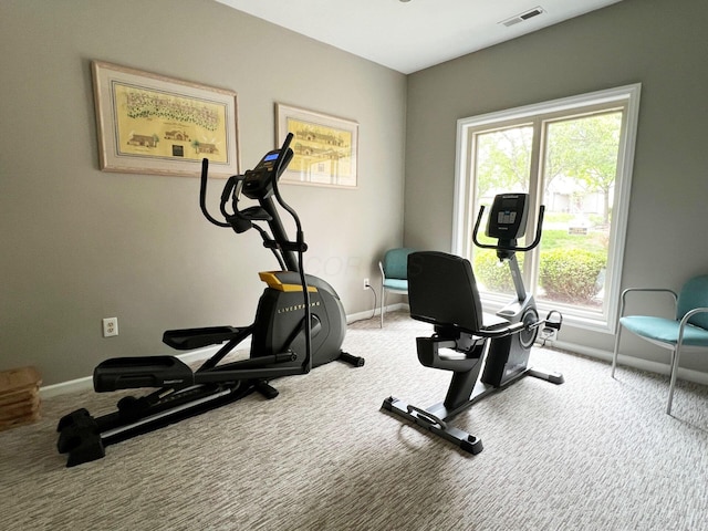 exercise room with carpet floors, baseboards, and visible vents