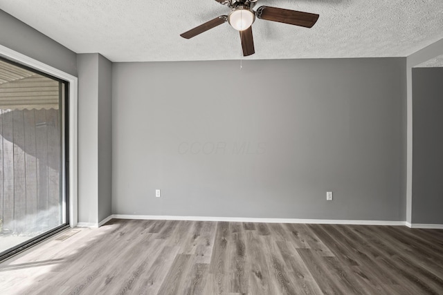 empty room with wood finished floors, a textured ceiling, baseboards, and ceiling fan