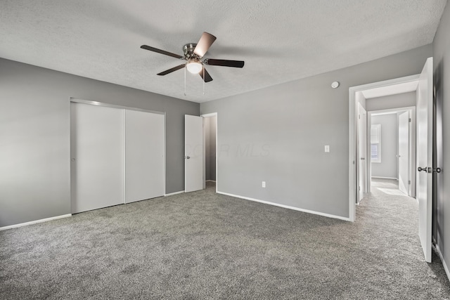 unfurnished bedroom featuring carpet, baseboards, and a textured ceiling
