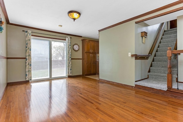1738 W Chestnut St, Lancaster, OH 43130 - unfurnished living room with crown molding, light wood finished floors, baseboards, and stairway