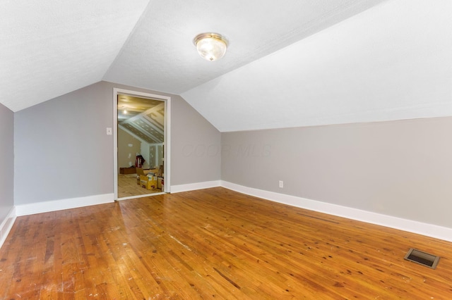 1738 W Chestnut St, Lancaster, OH 43130 - additional living space with visible vents, baseboards, vaulted ceiling, and hardwood / wood-style flooring