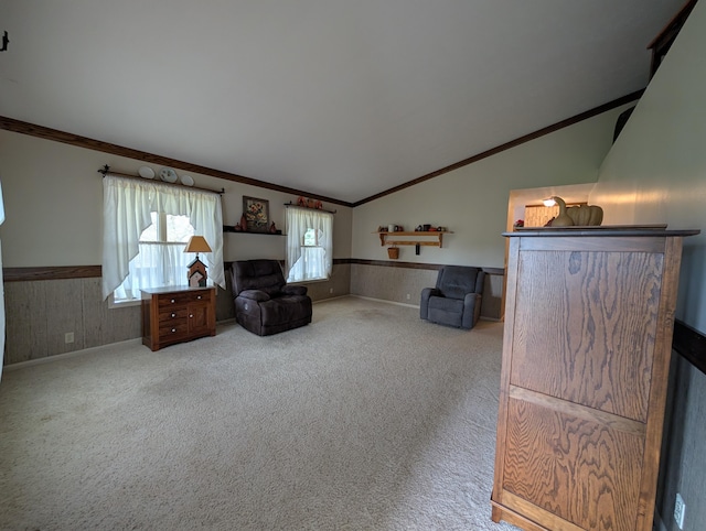 living room featuring carpet flooring, ornamental molding, a wainscoted wall, and lofted ceiling