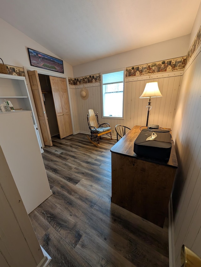 living area with dark wood-style flooring, wood walls, and lofted ceiling